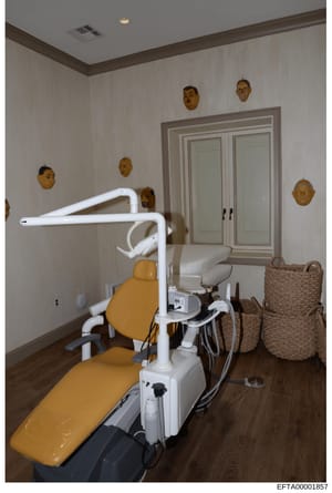 This is an evidence photograph showing the interior of a dental treatment room, likely from one of Jeffrey Epstein's properties. The room contains a professional dental chair with yellow upholstery, overhead dental lamp, and associated equipment. The