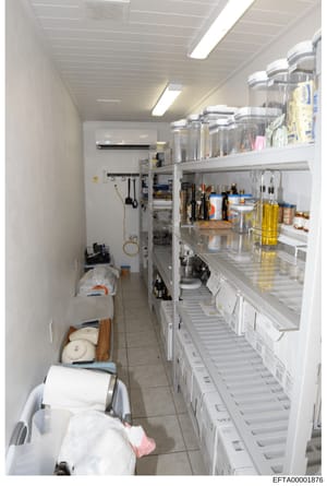 This is an evidence photograph of a residential kitchen pantry or storage area, showing organized shelving with various food items, cooking supplies, and household products. The image documents the interior storage space of what appears to be a prope