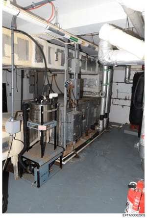 This photograph documents the interior of a mechanical/utility room, likely from one of Epstein's properties. The image shows various HVAC equipment, ductwork, piping systems, and electrical components. The photo appears to be evidence documentation 