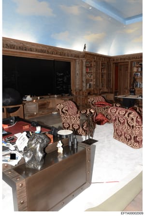 This photograph documents an upscale residential interior featuring a sophisticated office and library area with custom wood paneling, built-in cabinetry, decorative furnishings, and artwork. The image appears to be from a property inspection or evid