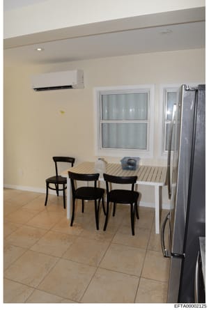 This is an evidence photograph showing the interior of a residential kitchen and dining space, featuring modern appliances, furnishings, and décor. The image appears to be part of property documentation or evidence collection related to an Epstein-as