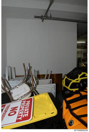 This is an evidence photograph showing the interior of a storage room or warehouse space containing various equipment and supplies. The image captures stacked chairs, sports/recreational equipment including items with yellow and orange straps, a yell