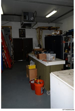 This is an evidence photograph showing the interior of a workshop or storage space containing various tools, equipment, and supplies. The room features workbenches, storage cabinets, and organized tool racks, suggesting this may be a maintenance area