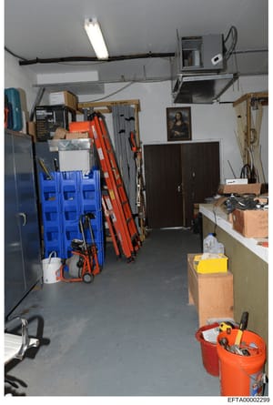 This photograph shows the interior of a garage or workshop space containing various tools, equipment, and storage items. The image includes ladders, tool storage bins, boxes, and miscellaneous equipment. This type of evidence photograph may document 