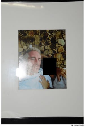 This is an evidentiary photograph from the Epstein investigation files showing a person wearing a light blue shirt against a decorative stone or tile background. A significant portion of the individual's face and body has been redacted with black cen