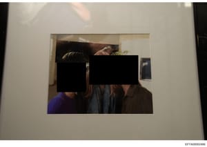 This is a photograph showing three individuals in an indoor residential or office setting with significant portions of their faces obscured by black redaction boxes. The setting appears to be a well-appointed interior space with decorative plants and