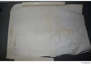 This is a photograph of a rolled architectural blueprint or property map document, yellowed with age and showing faint sketch lines and annotations. The document appears to be a historical architectural or property plan, possibly relating to one of E