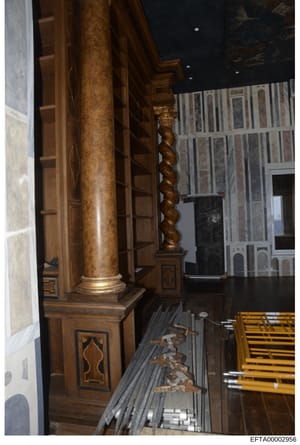 This photograph documents the interior architectural details of one of Jeffrey Epstein's properties, showing ornate wooden columns with decorative capitals, inlaid woodwork, and furniture arrangement. The image captures evidence of the luxury and cus