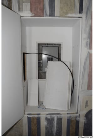 This photograph shows an interior space under construction or renovation, featuring white drywall, exposed framing, and electrical wiring. The image appears to be documentation of property conditions or construction work, likely from one of Epstein's