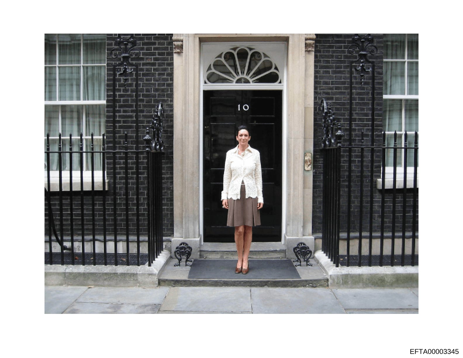 This is a color photograph showing a woman standing on the steps in front of the iconic black door marked with the number '10' at 10 Downing Street in London. The photo captures the famous entrance to the British Prime Minister's residence, with its 