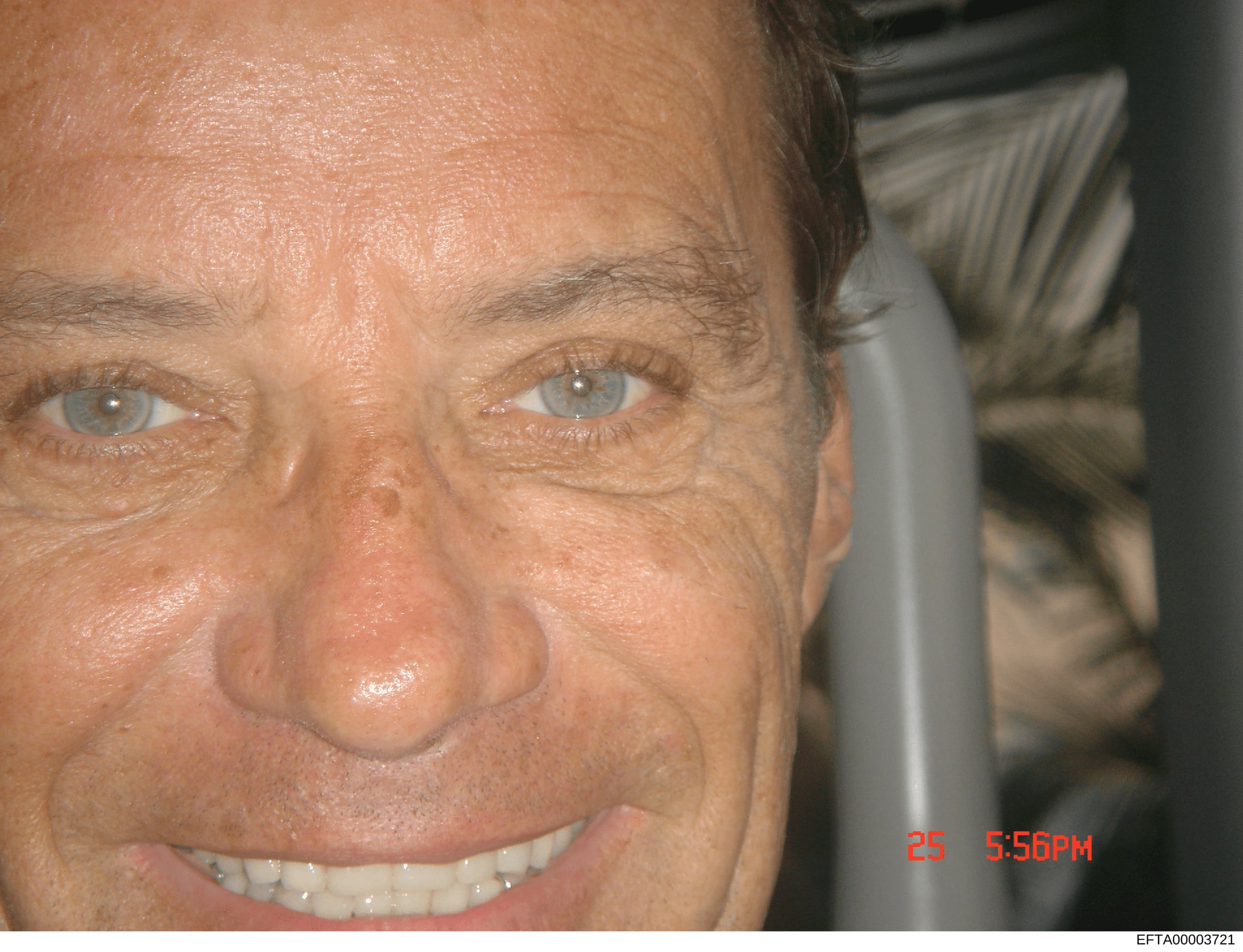 This is a close-up photograph of a man's face, showing facial features in detail. The image is stamped with a date of '25' and time of '5:56PM' in red text in the lower right corner. The photo appears to be evidence documentation from the investigati