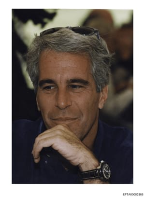 This is a professional portrait photograph of Jeffrey Epstein, showing him in a posed position with sunglasses pushed atop his head, wearing a dark blue shirt, and resting his chin on his hand. The photo appears to be from the 1990s or early 2000s ba