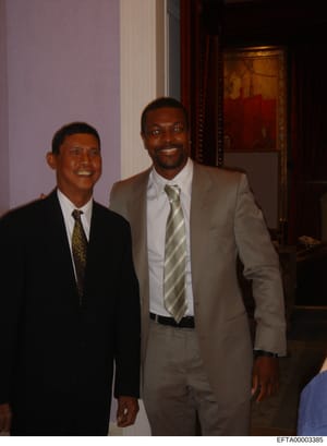This photograph shows two men in business attire smiling at what appears to be an indoor social or professional event. The image is undated and the individuals are unidentified in the document. The photo was preserved as part of the Epstein investiga