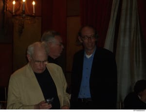 This is an evidence photograph showing three men in formal attire at an indoor event or gathering. The setting appears to be an upscale interior space with candlelit wall sconces and burgundy/dark decor. The identities of the individuals are not esta