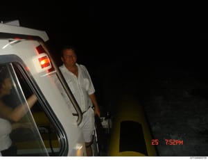 This is a photograph taken at 7:52 PM on the 25th of an unspecified month and year, showing a man in light-colored clothing exiting or standing beside a white vehicle with its tailgate open. The image appears to be from surveillance or investigative 