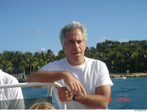 This is a casual personal photograph showing a middle-aged man with gray/white hair wearing a white t-shirt on what appears to be a boat or yacht. The background shows a tropical coastline with palm trees and clear blue water. The photo is dated 26 3