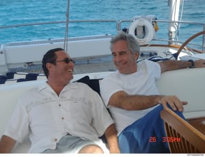 This is a candid photograph taken aboard a luxury yacht showing two men in casual summer attire enjoying time on the boat's deck. The photo was taken on what appears to be a sunny day with clear blue water visible in the background. The timestamp ind