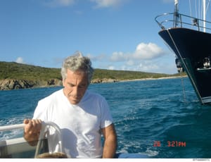 Photograph showing an older man with gray hair on a boat at sea, anchored near a green, rocky coastline. The image captures the subject at the helm of what appears to be a luxury vessel, dated approximately 2006 based on the timestamp visible in the 
