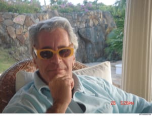 This is a casual personal photograph showing a man wearing yellow-framed sunglasses and a light blue shirt, seated outdoors at what appears to be a residential property. The photo was taken on May 26 at 5:26 PM, as indicated by the timestamp. The bac