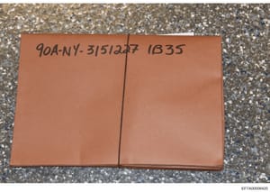 This photograph shows a sealed orange/brown folder or envelope marked with a case identifier '90A-NY-31512427' and the number '1835'. The folder appears to be physical evidence from the investigation, photographed on a textured surface as documentati