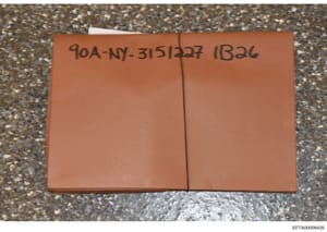 A photograph of a sealed orange/terracotta-colored folder or envelope bearing a handwritten case identifier (90A-NY-31512227 IB32c). The folder appears to be physical evidence or a container for documents related to the Epstein investigation. The ima