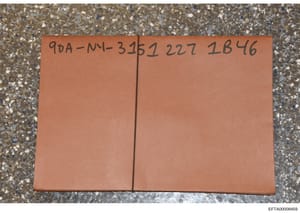 This photograph shows a sealed terracotta/orange-colored envelope or folder marked with a handwritten Bates reference number '90A-MM-3152 227 1846'. The envelope appears to be evidence documentation material, likely from the investigation file system